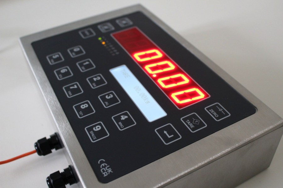 EXCELSIOR digital weigh terminal seen from a low side angle, with the cable glands on the side of the case